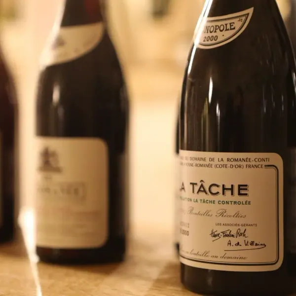 Bouteilles de vin La Tâche du Domaine de la Romanée-Conti posées sur une table en bois