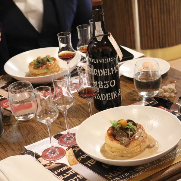 Une table avec des verres de vin, une bouteille de vin, des assiettes de nourriture et des couverts