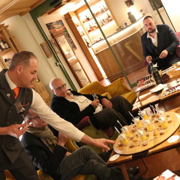 Un groupe de personnes assises dans un bar à vin dégustant des échantillons de vin et des chocolats